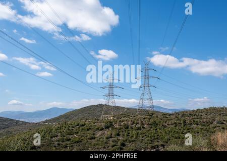 Lignes électriques haute tension et pylônes sur fond de montagne, ciel bleu Banque D'Images