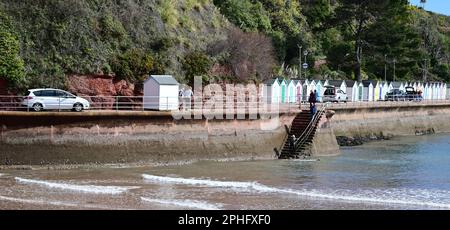 Une cabane de plage et une voiture se déplaçant le long de la promenade étroite de Goodrington Sands, South Devon (voir note). Banque D'Images