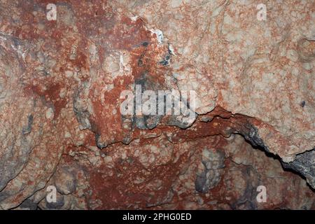 Gros plan d'une série de formations rocheuses présentant des stries de peinture rouge et blanche brillante Banque D'Images