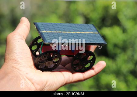 Voiture solaire en cellule photovoltaïque et 3D roues imprimées alimentées par un petit moteur c.c. tenu à la main Banque D'Images