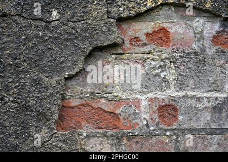 Mur de briques rendu avec un ciment dur qui craque et tombe Banque D'Images