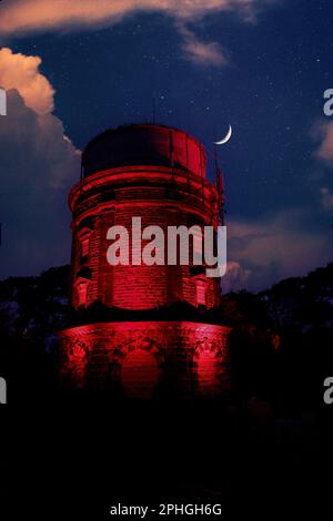 Tour aquatique emblématique illuminé par des spots rouges avec un ciel étoilé avec des nuages et une lune à crête, Harrogate, North Yorkshire, Angleterre, Royaume-Uni. Banque D'Images