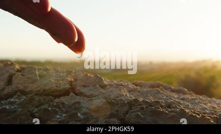 La main goutte de l'eau sur le sol Banque D'Images