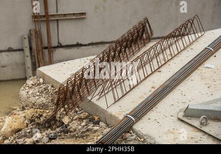 un faisceau de tiges d'acier et d'éléments d'acier de renforcement sur un plancher en béton d'un chantier de construction Banque D'Images