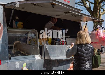 Femme achetant une crème glacée d'un commerçant de rue, à Embankment , Londres, Royaume-Uni Banque D'Images