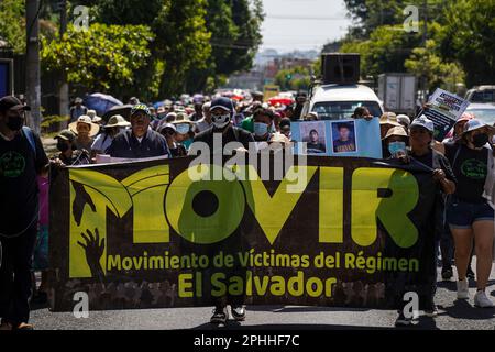 San Salvador, El Salvador. 28th mars 2023. Les manifestants défilent avec une bannière et des portraits de parents emprisonnés lors d'une manifestation contre l'état d'urgence placé par le Président Nayib Bukele. Le gouvernement salvadorien a mis en place un état d'urgence d'un an pour lutter contre les gangs, laissant plus de 66 000 prisonniers emprisonnés. Les organisations de défense des droits de l'homme prétendent que jusqu'à 10% des Salvadoriens emprisonnés pourraient être injustement emprisonnés. Crédit : SOPA Images Limited/Alamy Live News Banque D'Images
