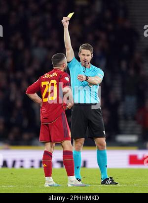 L'arbitre Sandro Scharer (à droite) présente une carte jaune au Dani Carvajal d'Espagne lors du match a du groupe de qualification de l'UEFA Euro 2024 au parc Hampden, à Glasgow. Date de la photo: Mardi 28 mars 2023. Banque D'Images