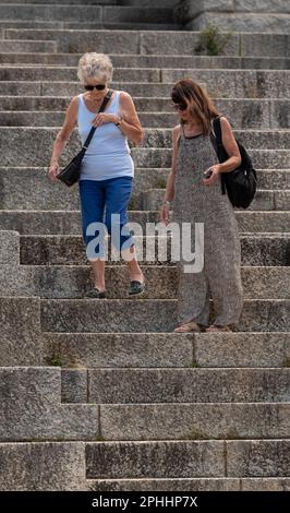 Le Cap, Afrique du Sud. 2023. Personne âgée qui obtient l'aide d'une femme soignant en marchant sur des marches très abruptes à une attraction touristique. Banque D'Images