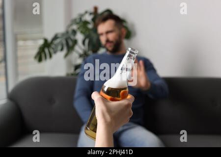 Homme refusant de boire de la bière à l'intérieur, en gros plan. Traitement de la dépendance à l'alcool Banque D'Images