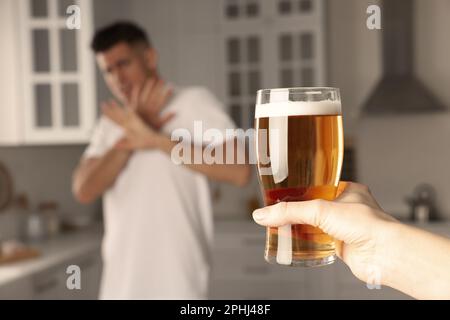 Homme refusant de boire de la bière dans la cuisine, gros plan. Traitement de la dépendance à l'alcool Banque D'Images