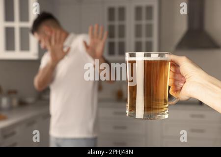 Homme refusant de boire de la bière dans la cuisine, gros plan. Traitement de la dépendance à l'alcool Banque D'Images