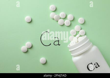 Composition de la couche plate avec des comprimés de calcium sur fond vert clair Banque D'Images
