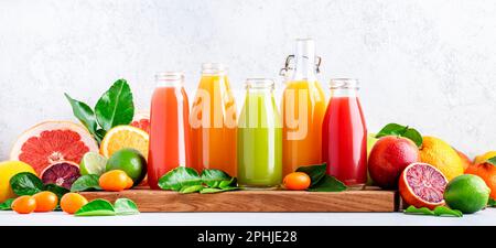 Boissons d'été. Jus d'agrumes, frais et smoothies, fond de nourriture. Mélange de différents fruits entiers et coupés : orange, pamplemousse, lime, mandarine Banque D'Images