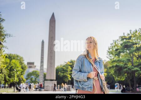 Femme touristique à Istanbul contre le fond de l'Obélisque de Theodosius est l'obélisque égyptien antique de Pharaon Thutmose III places dans le Banque D'Images