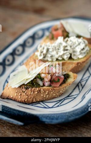 Tapas avec bruschetta et fromage aux herbes crémeux sur toast dans un restaurant rustique Banque D'Images