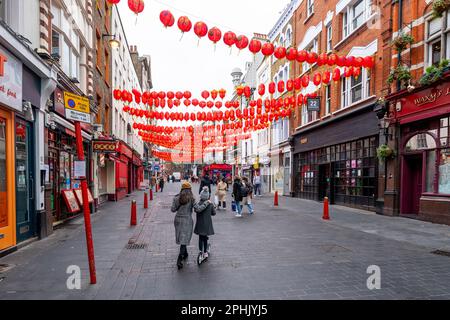Londres, Royaume-Uni - 13 février 2023: Personnes indéfinies et bus rouge à impériale dans l'avenue Shaftesbury qui est le chemin vers la ville de Chine au nord. Menton Banque D'Images
