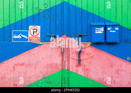 Porte de garage peinte avec de larges bandes obliques de couleur bleu-vert-rouge. Boîtes aux lettres. Bruxelles. Banque D'Images