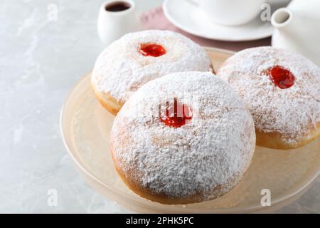 Délicieux beignets avec de la gelée et du sucre en poudre sur un présentoir à pâtisseries, gros plan Banque D'Images