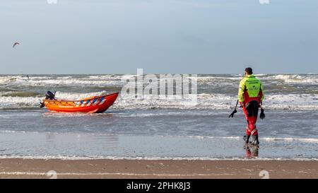 Un maître-nageur hollandais marchant jusqu'à un canot dans les vagues par une journée ensoleillée. reddingsbrigade=équipe de secours Banque D'Images