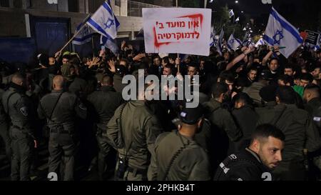 Des membres des forces de sécurité israéliennes ont renvoyé des manifestants anti-gouvernement qui tentaient de pénétrer dans le bâtiment du domicile privé du Premier ministre Benjamin Netanyahou lors d'une manifestation en réponse au congédiement du ministre de la Défense Yoav Galant, après qu'il ait demandé au gouvernement de mettre fin à ses réformes judiciaires controversées le mois de mars 26, 2023 à Jérusalem, Israël. Banque D'Images