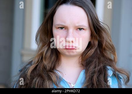 Offensé petit garçon regardant l'appareil photo. Aspect caucasien. Mauvais état émotionnel. Pas d'humeur. Puni bébé fille adolescente offensé bouted ses lèvres regarde dans le cadre 13 15 ans Banque D'Images