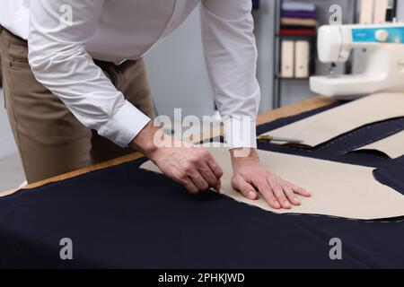 Couturière marquant le tissu avec de la craie dans l'atelier, en gros plan Banque D'Images