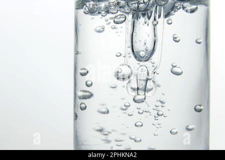 Pipeter dans un flacon de sérum cosmétique. Une bulle d'air dans un pot. Photo macro. Rétroéclairage. Gel Oxygel, Banque D'Images