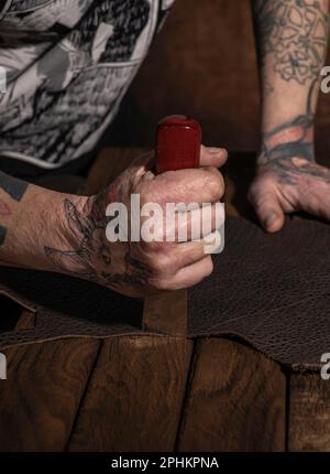 Cuir naturel couleur marron avec outils de travail artisanal. Concept de fond avec les mains de l'artisan. Banque D'Images