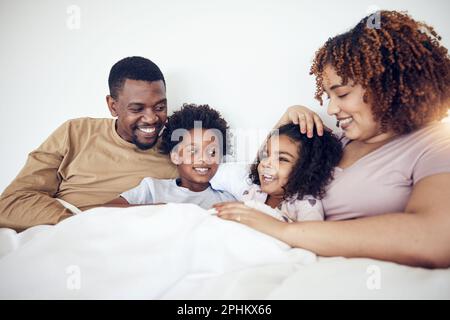 Famille, père et mère avec des enfants au lit se détendre ensemble pour un matin amusant ou des vacances à la maison. Joyeux papa, maman et enfants se détendre et s'allonger Banque D'Images