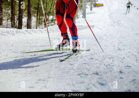 Athlète skieur en montée en compétition de ski, ski de course Fischer, chaussures de ski Rossignol, HuTag frid TAG dans les jambes, sports olympiques d'hiver Banque D'Images