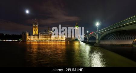 La nuit à travers la Tamise, le Parlement ou le palais de Westminster à Londres, en Angleterre. Le lieu de rencontre de la Chambre des communes et des lords Banque D'Images