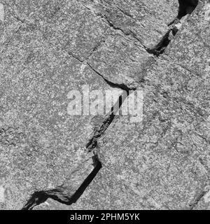 Grande fissure profonde sur le mur avec des restes de vieux plâtre, image abstraite de la fente diagonale. Gros plan. Photo en noir et blanc. Copier l'espace. Mise au point sélective. Banque D'Images