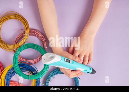 Les enfants ont des mains de 3D têtes de stylo sur le tas coloré de plastique. Jeux de loisirs et jouets modernes Banque D'Images