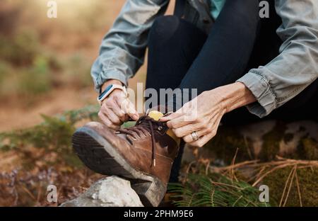 Gros plan, mains et chaussures de cravate pour la marche, la randonnée et l'entraînement pour un style de vie sain, le bien-être et le cardio. Personne, randonneur et cordonnier pour la forme physique Banque D'Images