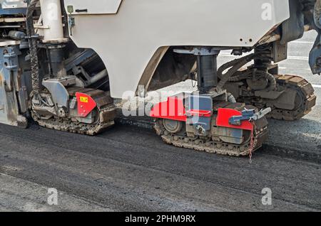 Fraiseuse de chaussée dans le vrai travail de préparation de la chaussée d'asphalte pour poser une nouvelle couche d'asphalte. Train de roulement de la fraiseuse de chaussée Banque D'Images