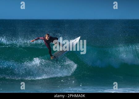 Une surfeuse femelle qui fait une vague à Fistral à Newquay en Cornouailles en Angleterre au Royaume-Uni. Banque D'Images