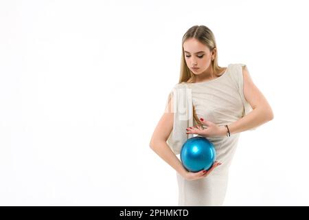 Gymnaste de fille vêtu d'une robe de soirée avec une balle sur fond blanc Banque D'Images