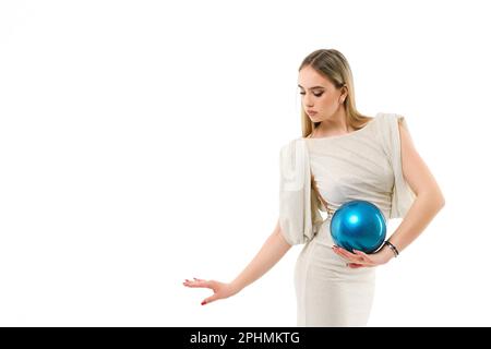 Gymnaste de fille vêtu d'une robe de soirée avec une balle sur fond blanc Banque D'Images