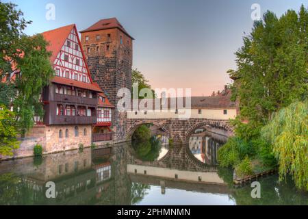 Vue au coucher du soleil sur le bâtiment Weinstadel, le château d'eau, le pont Hencurbrücke et la tour Henkerturm à Nuremberg, en Allemagne. Banque D'Images