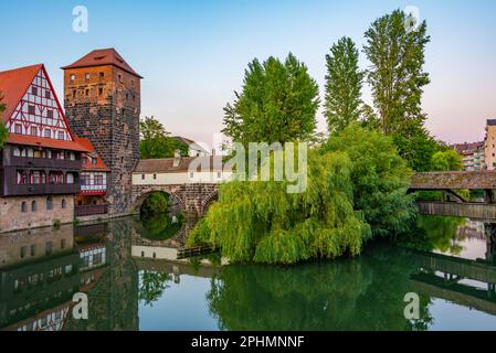 Vue au coucher du soleil sur le bâtiment Weinstadel, le château d'eau, le pont Hencurbrücke et la tour Henkerturm à Nuremberg, en Allemagne. Banque D'Images