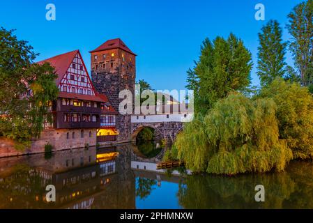 Vue au coucher du soleil sur le bâtiment Weinstadel, le château d'eau, le pont Hencurbrücke et la tour Henkerturm à Nuremberg, en Allemagne. Banque D'Images