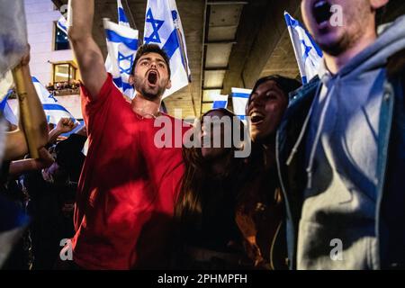 Tel Aviv, Israël. 25th mars 2023. Les manifestants anti-réformes élèvent leurs poings et leur chant sur la route bloquée d'Ayalon lors d'une manifestation anti-réforme à tel Aviv. Plus de 230 000 000 personnes protestent à tel Aviv contre le gouvernement d'extrême droite de Netanyahou et sa réforme juridique controversée. Crédit : SOPA Images Limited/Alamy Live News Banque D'Images