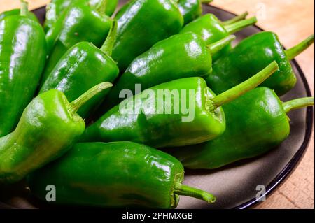 Pementos doux au poivre de padron vert frais, prêts à griller ou à frire avec de l'huile d'olive, en-cas traditionnel en Galice, Espagne. Banque D'Images