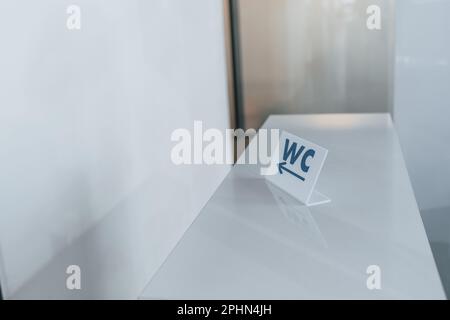 Affiche avec des mots de toilette sur elle montrant la direction vers les toilettes à l'intérieur Banque D'Images