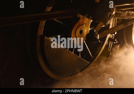 vapeur de la roue de fer de locomotive avec de la fumée flottant sur le chemin de fer la nuit Banque D'Images