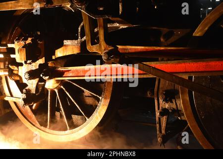 vapeur de la roue de fer de locomotive avec de la fumée flottant sur le chemin de fer la nuit Banque D'Images