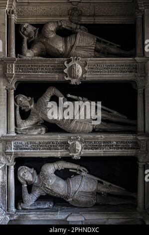 Sur l’étagère : les patriarches de la famille Fettiplace des années 1500 et du début des années 1600, portant une armure Tudor, reposent fermement sur les coudes dans un monument unique de chœur à plusieurs étages dans l’église paroissiale St Mary’s dans le village de Swinbrook, Oxfordshire, Angleterre, Royaume-Uni. La maison construite sur le site de leur manoir appartenait à Lord et Lady Redesdale, qui reposent dans le cimetière avec quatre de leurs filles controversées : Pamela, Nancy, Diana et Unity Mitford. Banque D'Images