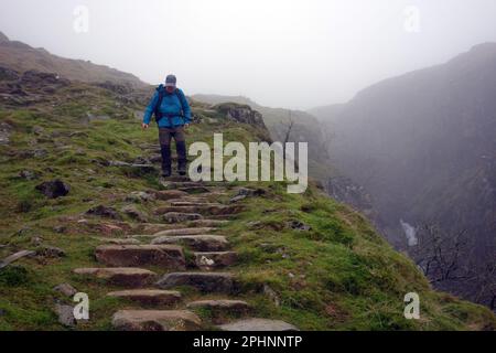 Man (Hiker) descendre sur le chemin par Ruddy Gill de Scafell Pike via Esk Hause à Stockley Bridge et Seathwaite à Borrowdale, Cumbria, Angleterre, Royaume-Uni. Banque D'Images