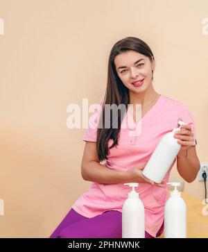 Une femme cosmétologue présente des boîtes de distributeurs de produits cosmétiques Banque D'Images