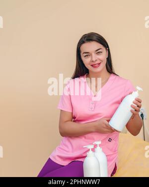 Une femme cosmétologue présente des boîtes de distributeurs de produits cosmétiques Banque D'Images